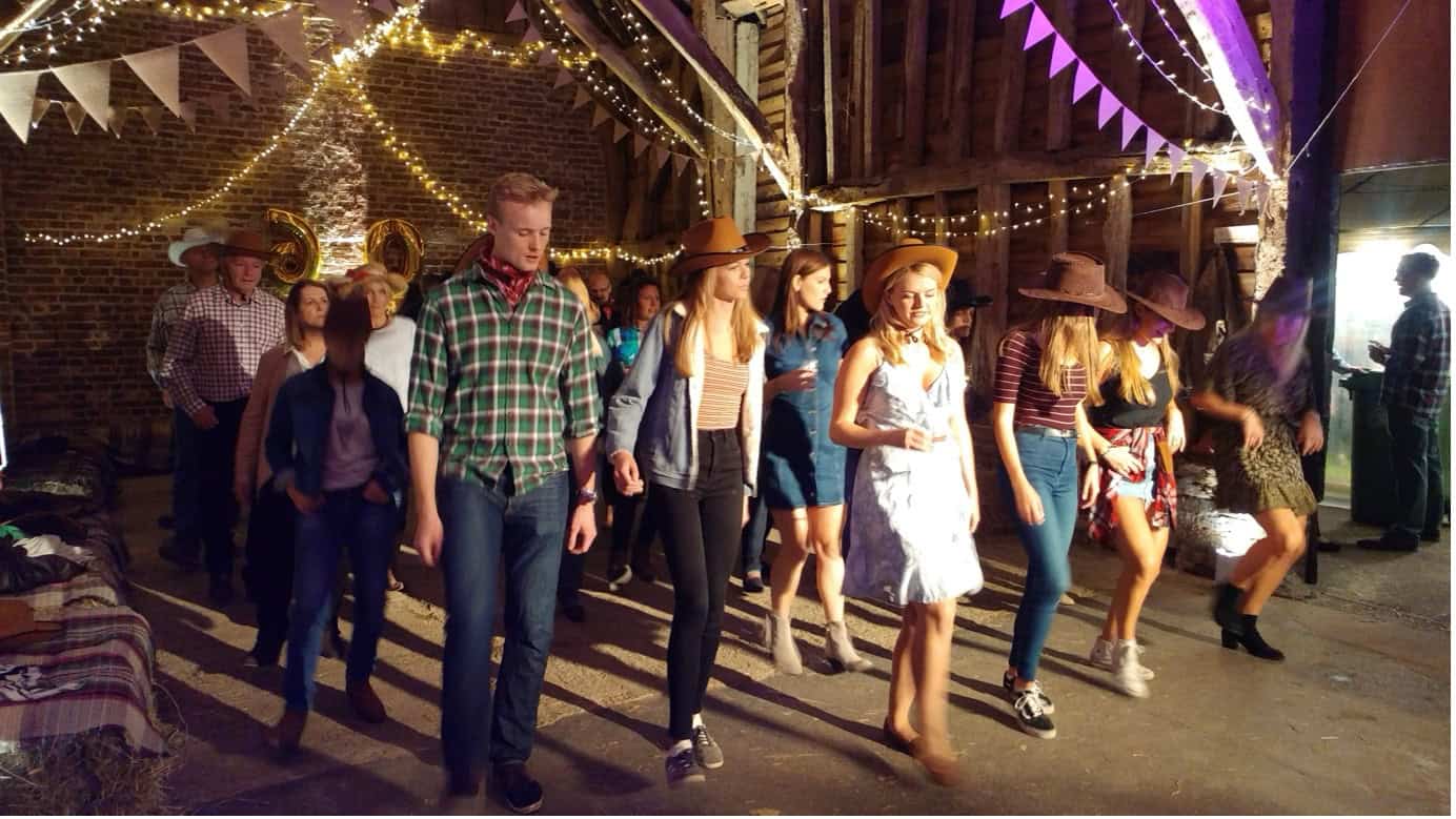 Guests line dancing at a country and western themed party