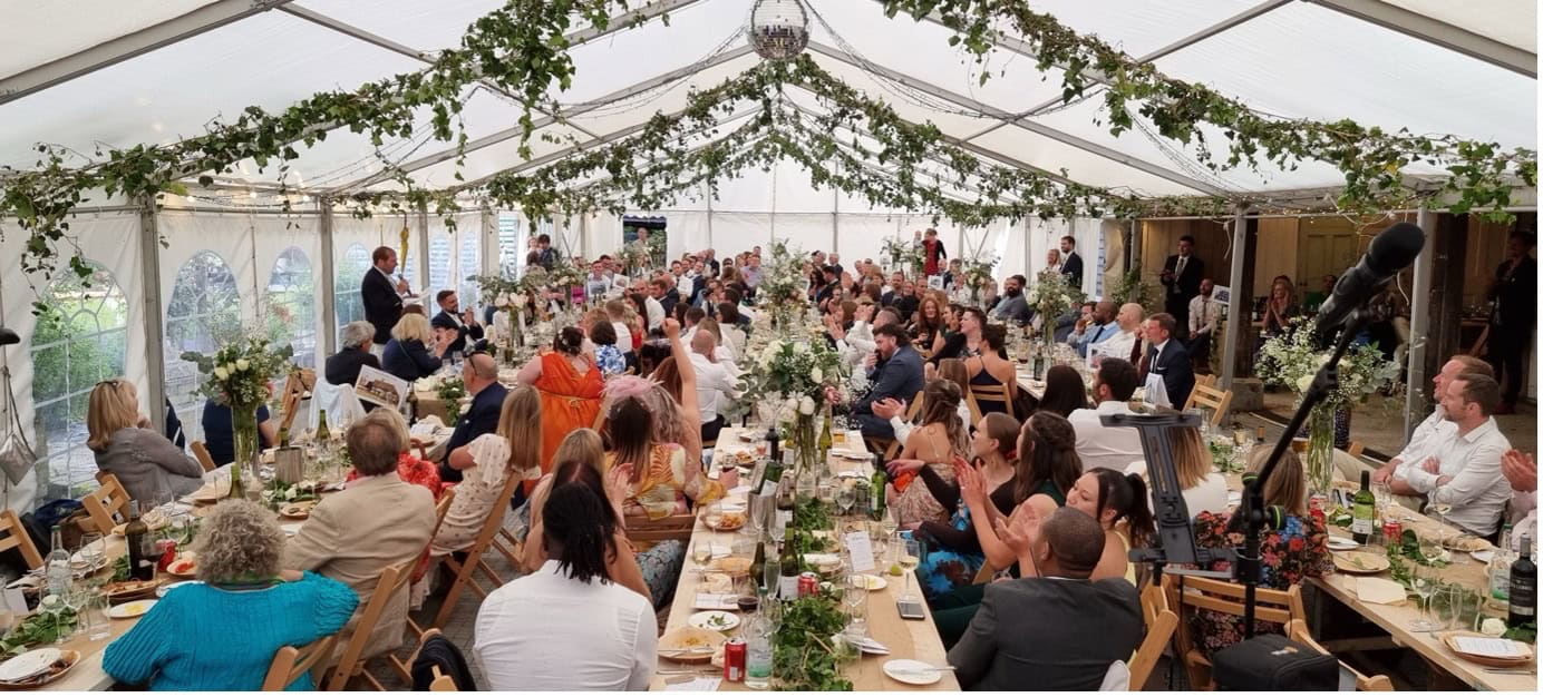 Wedding reception in decorated marquee with guests dining